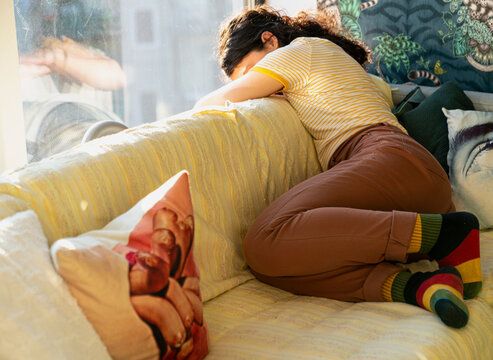 Beautiful brunette resting on a couch by window 