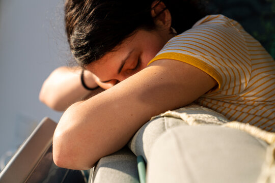 Beautiful brunette resting on a couch by window 