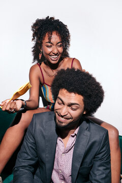 Black couple laughing and styling afro hair