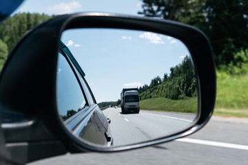 Reflection of the road in the mirror of the car while driving.