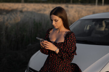 portrait of attractive beautiful woman with mobile phone near car	
