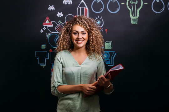Smiling blonde woman with folder in modern creative office