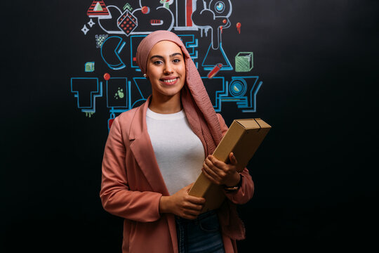 Smiling Muslim worker with folder in modern office