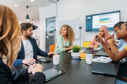 Crop Cheerful Multi Coworkers Talking At Office Table