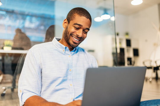 Cheerful analyst man using laptop in office