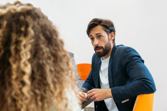 Coworkers talking at office table