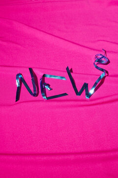 The inscription New from tinsel on a pink background