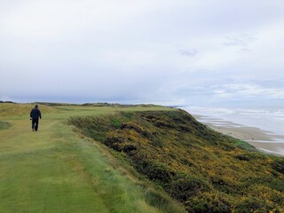 Obraz premium A man walking along the oregon coast with the pacific ocean visible in the background