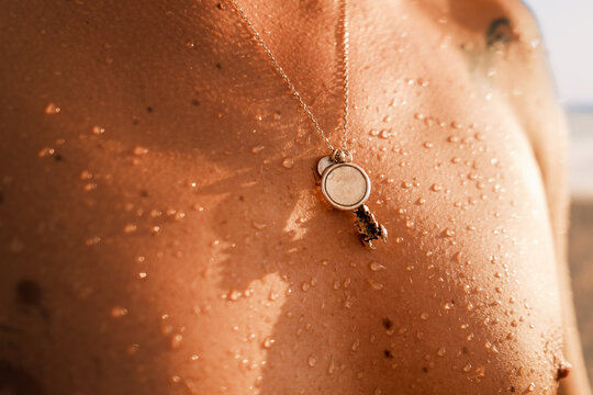 naked torso with water droplets at sunset time