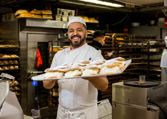 Cheerful baker offering fresh buns to camera