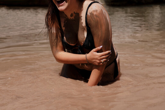 Girl enjoying mud-bathing