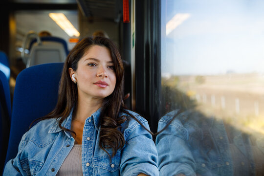 Thoughtful passenger listening music through earphones in train