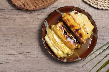 Grilled cassava topped with sweet coconut milk. Thai dessert.