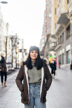 Portrait of a cheerful young woman in winter clothes in the city
