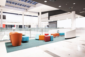 A children's playground are colored seats in an area of a shopping center