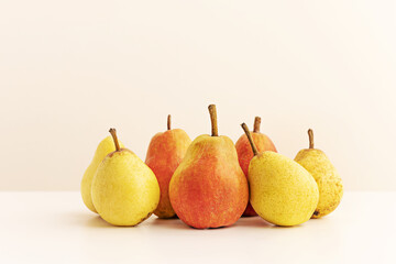 A bunch of fresh ripe pears of two kinds with their stems up
