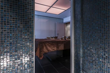 Wallpaper murals Massage parlor A blue glass tiled sauna in a massage parlor with Tibetan bowls on a table