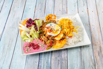 A combination plate of Middle Eastern recipes with rice, hummus, fresh cheese and salad