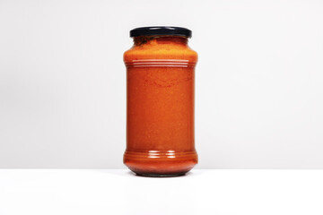 Image of a liter boat of tomato sauce on white surface