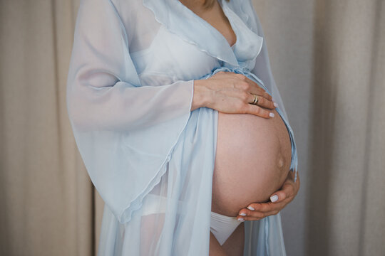 Attractive pregnant woman in blue dress. Motherhood and healthcare concept