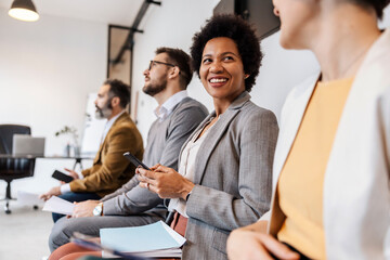 A multiracial mentees are sitting at corporate firm and waiting for the meeting at the office. The...