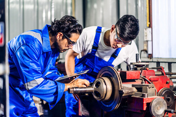 Professional two labor machanic engineer technician worker industrial man wearing blue safety uniform working control with heavy machine in manufacturing  factory production line.business industry