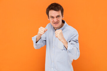 Portrait of angry aggressive man standing clenched fists and being ready to attack, fighting,...