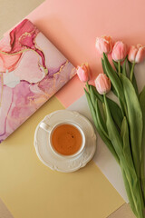 cup of tea on  table with bouquet of flowers tulips and laptop
