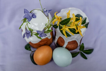 two Easter cakes with floral decor and colorful eggs. view from above