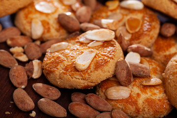 Pile of shortbread almond biscuits and nuts on wooden surface ..