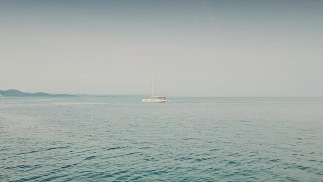 A sailboat on the open sea. minimalist footage. distant camera. bird's eye view. Top above view. Calm scenery of sea. 4k quality