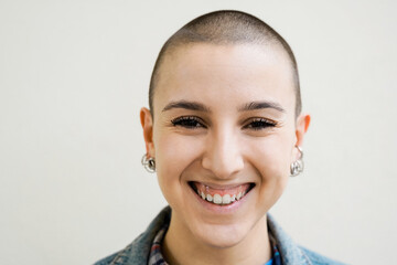 Happy bald young woman smiling on camera outdoors - Diversity, androgynous concept - Focus on face
