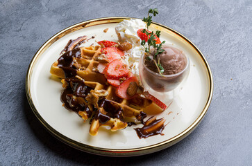 waffles, with berries, nuts & fruit on a gray table, served with ice cream breakfast, no people, horizontal,