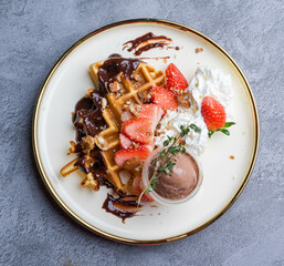 waffles, with berries, nuts & fruit on a gray table, served with ice cream breakfast, no people, horizontal,