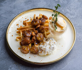 waffles, with berries, nuts & fruit on a gray table, served with ice cream breakfast, no people, horizontal,