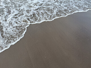 Soft wave of the ocean on Parangtritis Beach with black sand located in Yogyakarta, Indonesia.
