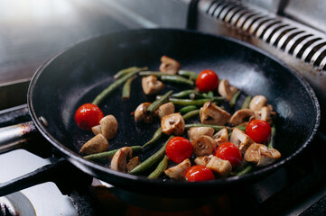 cooking vegetables in a pan on a gas stove