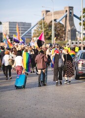 crowd of people waving rainbow and pride flags on pride parade under Grunwaldzki Bridge in...