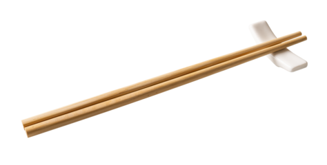 Wooden chopsticks on a white chopstick rest cutout. Pair of bamboo chopsticks on a porcelain holder  isolated on a white background. Japanese, Chinese, East Asian tableware concept.