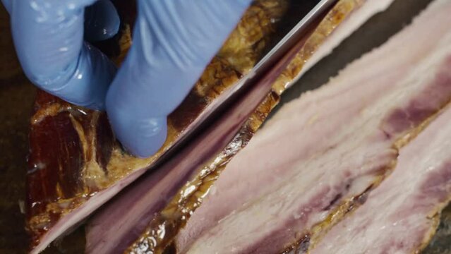 Closeup slicing a beautiful piece of bacon in plong&eacute;e