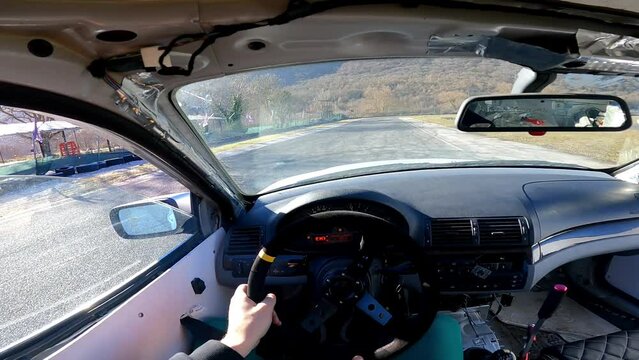 Professional driver drifting on special training playground, man inside the drift car accelerating speed and making abrupt maneuvers. Car drifting techniques and adrenaline feeling