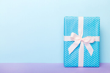 holiday handmade paper present tied white ribbon bow top view with copy space. Flat lay holiday background. Birthday or christmas present. Christmas gift box concept with copy space