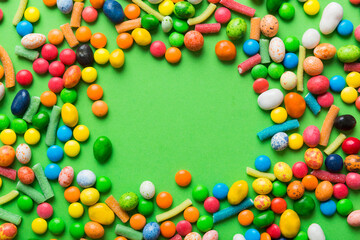 Mixed collection of colorful candy, on colored background. Flat lay, top view. frame of colorful chocolate coated candy