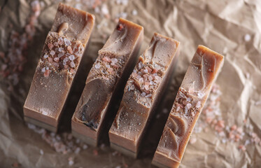 Pieces of delicate pink green natural handmade soap on craft paper. Concept of creating and using organic eco soap and cosmetics