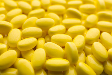 Pile of tasty yellow dragee candies as background, closeup