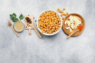 Delicious chickpeas and different ingredients on light grey table, flat lay with space for text. Cooking hummus