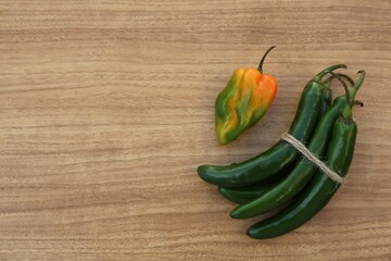 Different fresh ripe peppers on wooden table, flat lay. Space for text