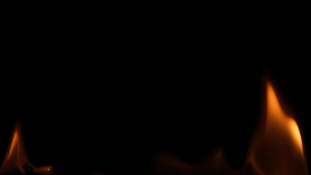 Close-up of burning paper with fire element isolated on black background. flame stream