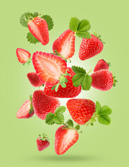 Delicious sweet strawberries and leaves falling on light green background