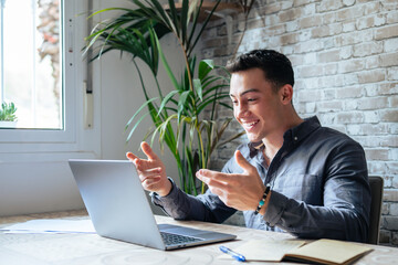 Concentrated skilled millennial caucasian businessman in glasses wearing headphones with mic, taking part in online web camera negotiations meeting using computer app, distant communication concept..